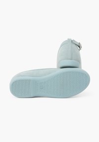 Light blue suede shoes with a rounded toe and ankle strap featuring a metal buckle. Sole is textured rubber with a wavy pattern.