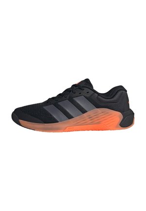 Chaussure de sport noire avec des rayures grises et une semelle orange épaisse, vue de côté sur fond blanc.