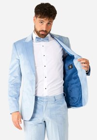 Traje de terciopelo azul claro con solapa de muesca, chaqueta de un solo botón, camisa de vestir blanca, botones negros y pantalones a juego. Se incluye pajarita.