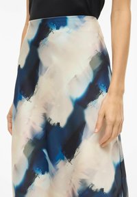 Et midtlangt skjørt med et abstrakt mønster i nyanser av blått, krem og grått, laget av glatt stoff med en flytende tekstur.