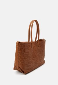 Hnědá kabelka z umělé kůže s krokodýlí texturou, má dva pevné úchyty a prostorný obdélníkový tvar.