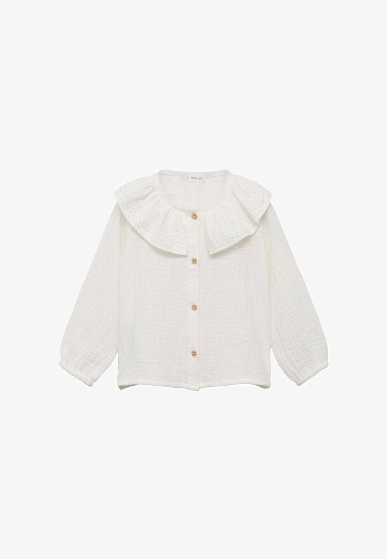 Chemise blanche texturée à boutons avec un grand col froncé et des manches longues bouffantes. Comprend des boutons en bois et des détails en œillets sur le col.