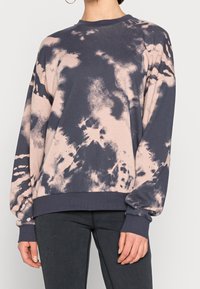 Felpa leggera a girocollo di colore blu navy scuro con motivo tie-dye rosa. Presenta maniche lunghe e polsini a costine all'orlo e alle maniche.