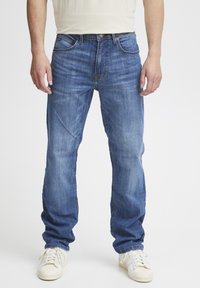 Jeans de denim azul claro con un diseño de pierna recta, que presentan un clásico estilo de cinco bolsillos y un sutil desgaste en la parte frontal.