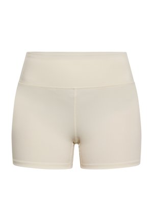 Shorts beige clair avec une taille haute, fabriqués en matériau extensible, présentant une texture lisse et des coutures minimales pour plus de confort.