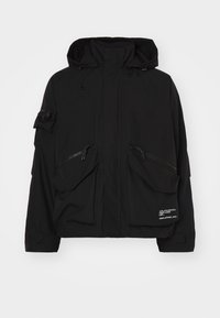 Black waterproof jacket featuring a high collar, multiple zippered pockets, and adjustable drawstrings on the hood and hem.