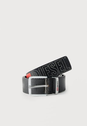 Must tekstuuriga nahkvöö hõbedase pandlaga, mille küljes on suurte tähtedega "DIESEL" brändi nimi ja väike metallist silt aasas.