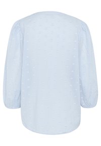 Blouse bleu clair en tissu doux, dotée d'un col rond, de manches longues et d'un motif en forme de cœur discret sur l'ensemble.