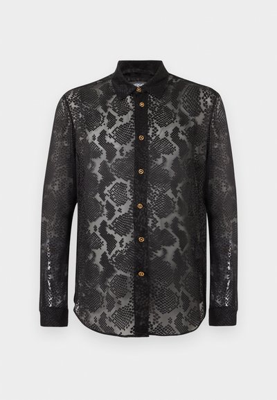 Chemise noire à manches longues en tissu transparent avec motif peau de serpent, col noir, poignets noirs et boutons dorés sur le devant.
