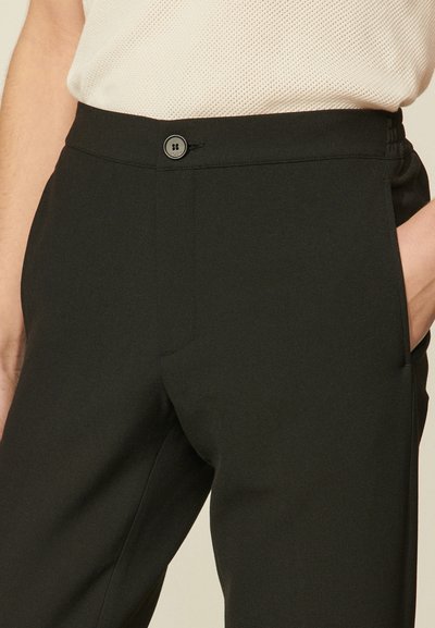 Zwarte broek met een getailleerd ontwerp, voorzien van een enkele knoopsluiting, zijzakken en een gladde stofstructuur.