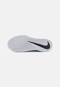 Nike Vapor potplat u bijelom gumenom materijalu s uzorkom riblje kosti i istaknutim crnim swoosh logotipom. Dizajniran za prianjanje i stabilnost.