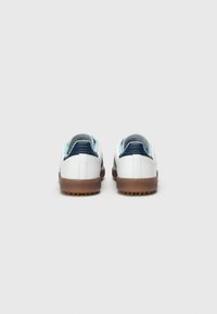 White sneakers with a smooth finish, light blue and navy accents, featuring a rounded toe, rubber sole, and rear pull tab.