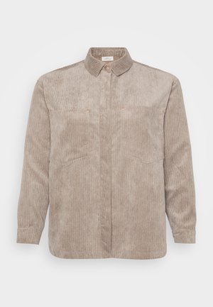 Beige corduroy shirt met een button-down kraag, twee borstzakken en lange mouwen. Heeft verticale ribbels en een subtiele glans.