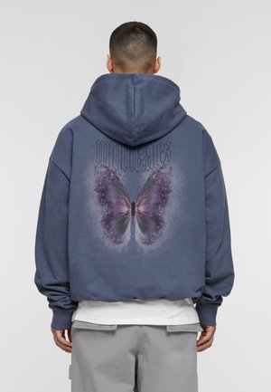 Navy blue hoodie with oversized fit, featuring a large purple butterfly graphic on the back and the word "gonzales" above it.