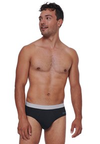 Schwarze kurze Unterwäsche mit einem grauen Bund, gefertigt aus weichem Material. Das Design ist eng anliegend mit einem niedrigen Schnitt.