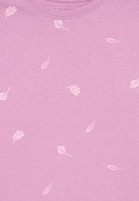 Ανοιχτό ροζ μπλούζα T-shirt με σχέδιο από μικρά λευκά φύλλα. Το ύφασμα φαίνεται απαλό και άνετο με κλασική στρογγυλή λαιμόκοψη.