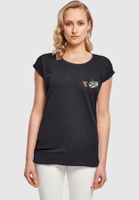 Juodas trumpas rankovė t-shirt, pagamintas iš minkštos medžiagos, su išsiuvinėtais Tomo ir Džerio simboliais kairėje krūtinės pusėje, su apvaliu iškirpimu.