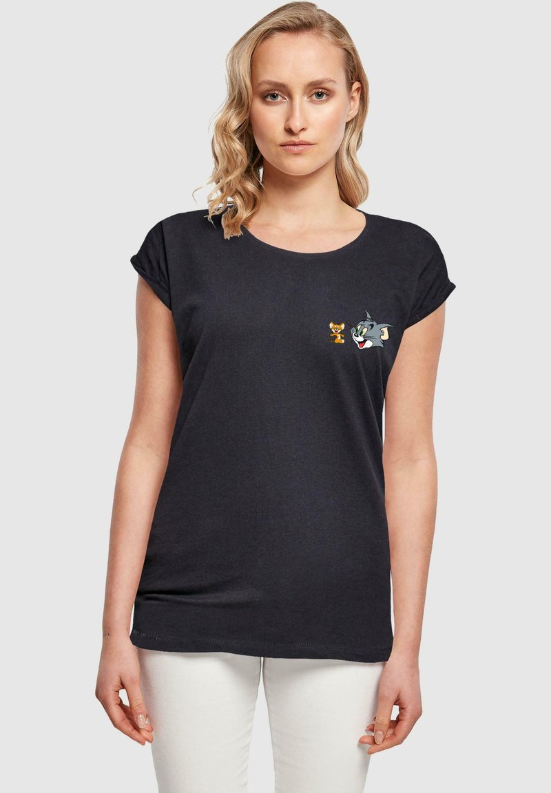 Juodas trumpas rankovė t-shirt, pagamintas iš minkštos medžiagos, su išsiuvinėtais Tomo ir Džerio simboliais kairėje krūtinės pusėje, su apvaliu iškirpimu.