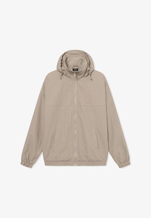 Beige letvægtsjakke med hætte, elastiske manchetter og en fuld frontlynlås. Har to sidelommer og et lille logopatch på brystet.