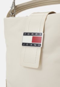 Tommy Jeans STARTDUST BUCKET BAG - Kabelka - offwhite