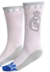 Calze bianche con accenti grigi, caratterizzate da un logo Real Madrid grigio ben visibile e punte blu. Texture a maglia con design a costine verticali.
