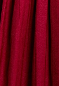 Tessuto cremisi con una superficie liscia e strutturata, caratterizzato da morbidi drappeggi e una sottile lucentezza, ideale per abbigliamento o tappezzeria.