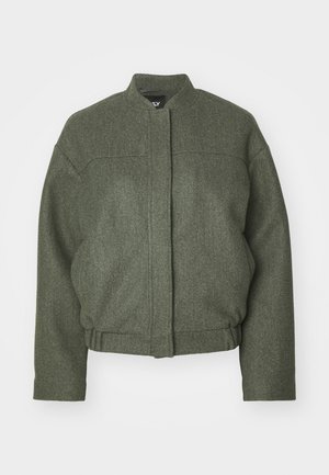 Roheline villasegu jakk seisva kraega, kasti kujuga, lühikese hemiga ja kahe esisegoga taskuga. Tekstureeritud kangas minimaalse õmbluse detailsusega.