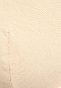 Beiger Rippstoff mit einer glatten Textur, der ein markantes Nahtdetail auf der linken Seite aufweist. Geeignet für die Herstellung von figurbetonten Kleidungsstücken.