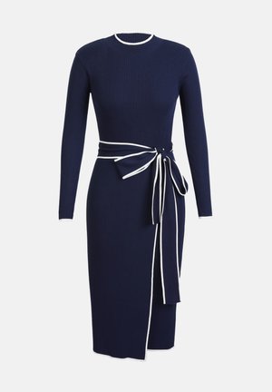 Abito a coste blu navy con maniche lunghe, scollo rotondo e rifiniture bianche. Presenta una cintura legata in vita e uno spacco laterale per un tocco di stile.