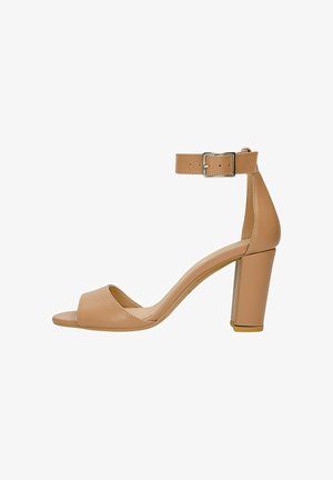 Beżowe sandały na obcasie z odkrytymi palcami, z paskiem na kostce, słupkiem, gładką skórzaną fakturą i subtelnym połyskiem. Posiadają metalową klamrę.
