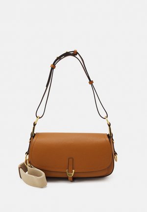 Sac à bandoulière en cuir marron avec des sangles noires réglables, des ferrures dorées et une large sangle accessoire en tissu beige sur un fond uni.