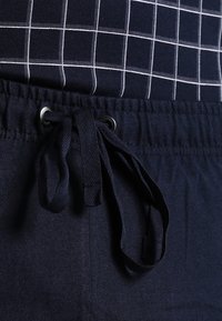 Shorts à cordon de serrage bleu marine en tissu doux, avec une taille tissée et un cordon assorti rehaussé de détails en œillets argentés.