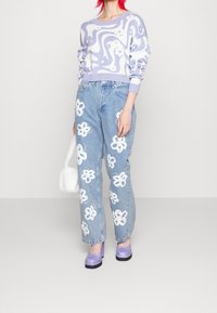 Light purple patterned sweater, light blue jeans with white flower embroidery, and lavender platforms; soft textures and relaxed fit.