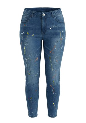 Siniset skinny-farkut, joissa maalispraysuunnittelu valkoisella, keltaisella, oranssilla ja mustalla, etu- ja takataskut sekä napillinen kiinnitys.