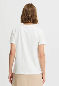 T-shirt blanc à manches courtes avec un col rond, fabriqué en tissu de coton lisse, arborant un design uni et un ourlet droit.