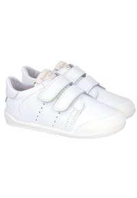 Zapatos de cuero blancos con dos correas de Velcro, punta redondeada, diseño perforado para ventilación y suela de goma texturizada para agarre.