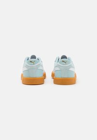 Sneakers azzurri chiari con tomaia texturizzata, dettagli bianchi e suola in gomma. Presentano un logo dorato sul tallone e un collo imbottito.