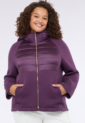 Chaqueta con capucha morada con un panel frontal acolchado, cierre de cremallera y bolsillos laterales. Presenta una tela suave y un ajuste relajado.