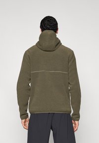 Φούτερ με κουκούλα σε ελιά πράσινο, με υφή υφάσματος, διαθέτει ραφή στην πλάτη και εφαρμοστά μανσέτες. Καθημερινό design, άνετη εφαρμογή.