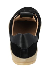 Scarpa in suede e pelle nera con punta arrotondata, dettaglio elastico sul tallone e suola in gomma beige. Fodera interna liscia visibile.