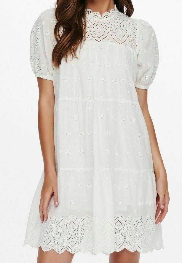 Robe blanche à manches courtes bouffantes, avec des détails en broderie anglaise et un ourlet festonné. Silhouette fluide avec un col rond et un design à volants.