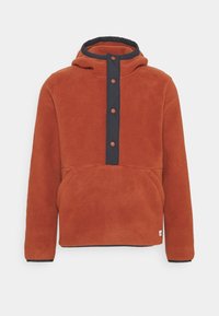 Felpa di pile color ruggine con cappuccio, bottoni frontali e una patta color navy. Include una tasca a marsupio e polsini e orlo a costine.