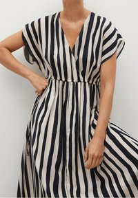 Maxikleid mit marineblauen und cremefarbenen Streifen, V-Ausschnitt, kurzen Ärmeln und elastischem Bund für eine lockere Passform. Weicher, glatter Stoff.