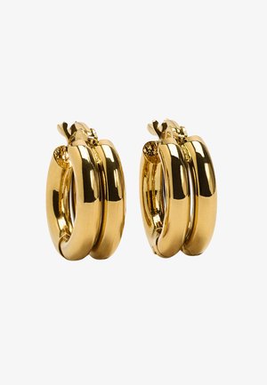 Kolczyki koła w złotym odcieniu z potrójnym paskiem, wykończone na wysoki połysk i z zapięciem na klips, prezentujące gładkie krzywizny i metaliczny blask.