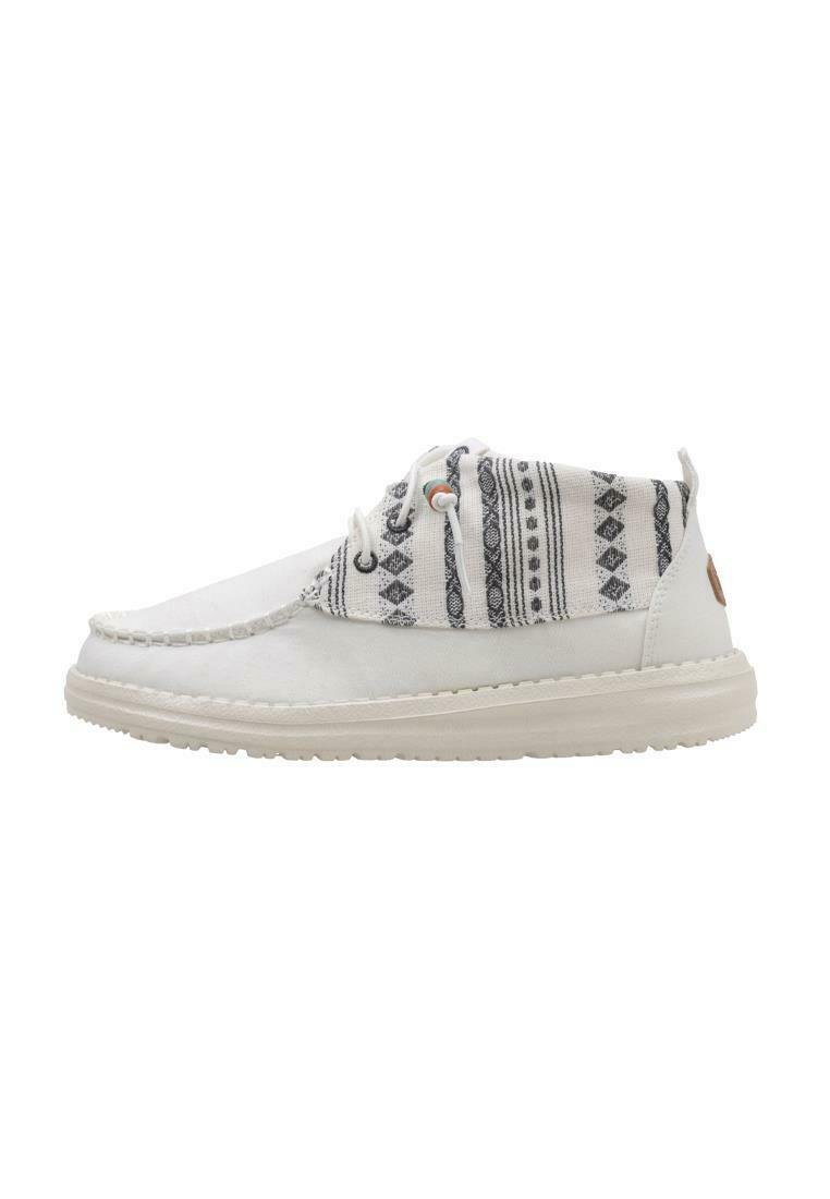 Zapatillas blancas casuales con un upper de tela estampada, suela texturizada en color crema y diseños geométricos en negro contrastante en el cuello.