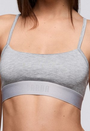 Grijze sportbeha met dunne bandjes, gladde textuur en een brede, elastische band met een ingeslagen logo. Eenvoudig, minimalistisch ontwerp.