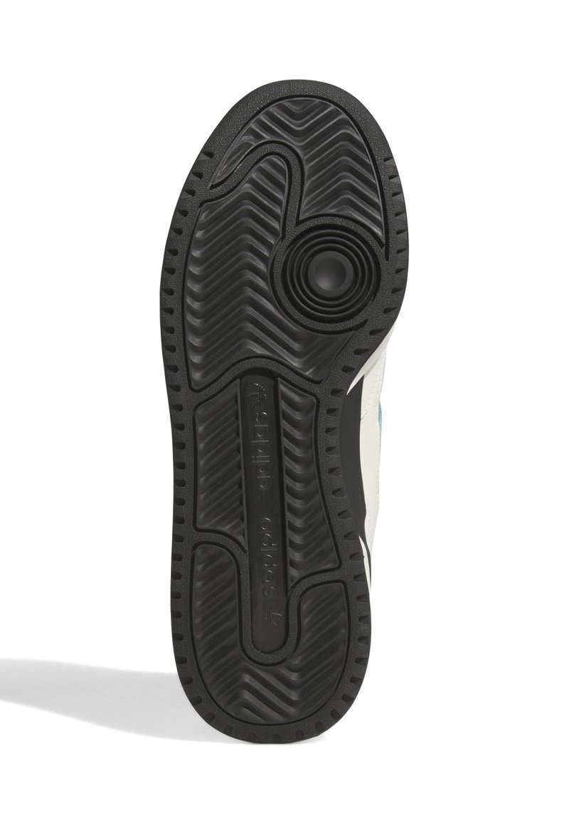 Semelle de sneaker en caoutchouc noir avec des rainures texturées, un accent circulaire et un détail de marque. Principalement plate avec une légère courbure.