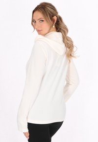 Hoodie aus weichem cremefarbenem Stoff mit langen Ärmeln und lockerer Passform. Die Rückansicht zeigt eine glatte Textur und ein schlichtes Design.
