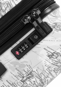 Schwarze Reißverschlussschnalle an einem Hartschalenkoffer mit weißem Kartenmuster. Enthält ein Zahlenschloss mit rotem Logo.