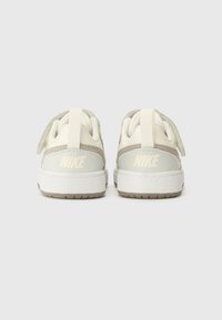 Baskets en cuir blanc avec des accents gris. Bout rond, col rembourré et une languette. Présente un logo Nike discret sur le talon.